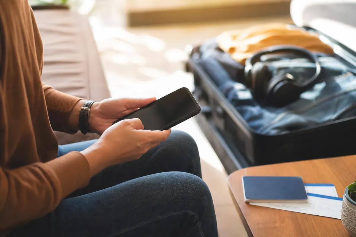 Relaxed traveler using their smartphone for a WhatsApp call abroad.
