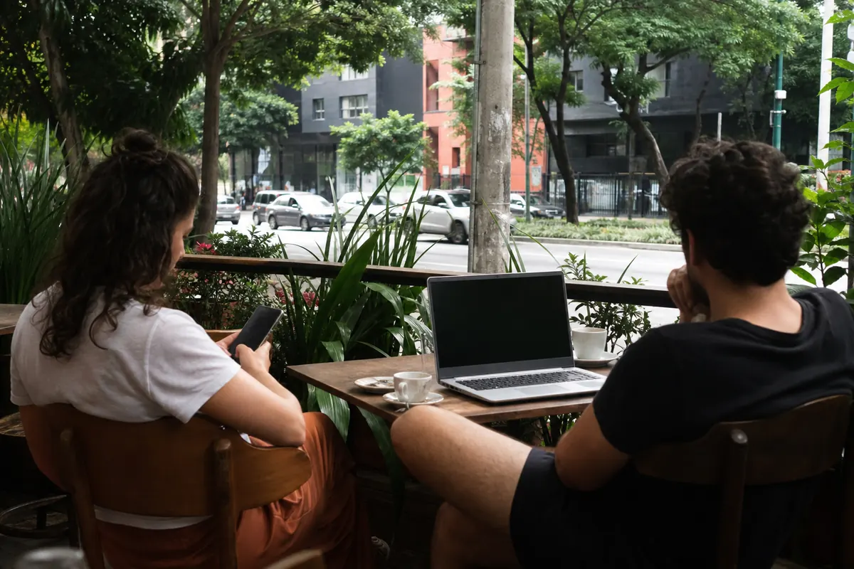 A connected traveler ordering a ride-share on their smartphone in São Paulo.